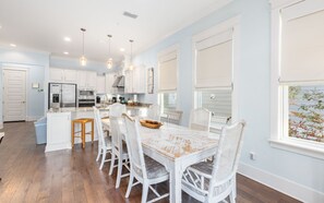 Enjoy meals in the kitchen with a central island, stainless steel appliances, and a dining area with a large table.