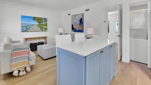 Un salon moderne avec un canapé blanc, un meuble bleu et une cheminée.