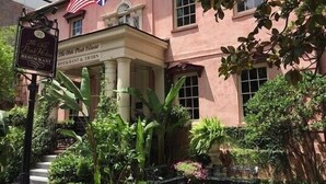 A building with a sign reading "The Old Pink House Restaurant" and flags of the UK and EU. - Classic Jones Street Apartment-Off Street Parking Spot Included! (Savannah)