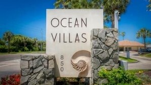 A sign for Ocean Villas with a spiral design and the number 850.