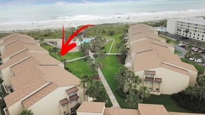 A beachfront hotel with multiple buildings, a pool, and a view of the ocean.