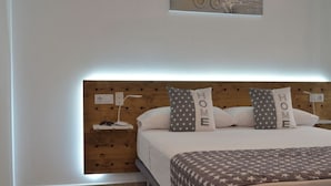 A neatly arranged bedroom with a wooden headboard, a bedside table with a lamp, and pillows with the word "HOME" on them. - 2.1 NEW in center ROSES with WI-FI, AC and TV sat at 60 m MAR (Roses)
