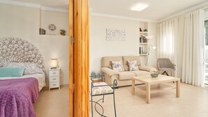 A well-lit living room with a bed, sofa, and a coffee table. - Fernandita Apartment for Couples with 2 Private Terraces, Wi-Fi & Barbecue, Near the Beach (Nerja)