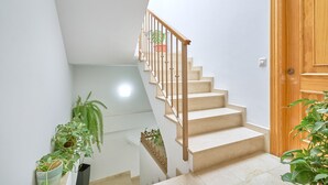 A staircase with beige steps and a wooden handrail, leading to a wooden door. - Fernandita Apartment for Couples with 2 Private Terraces, Wi-Fi & Barbecue, Near the Beach (Nerja)