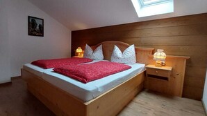 Ein Schlafzimmer mit einem Holzbett, einem Nachttisch mit Lampe und einem Oberlicht.
