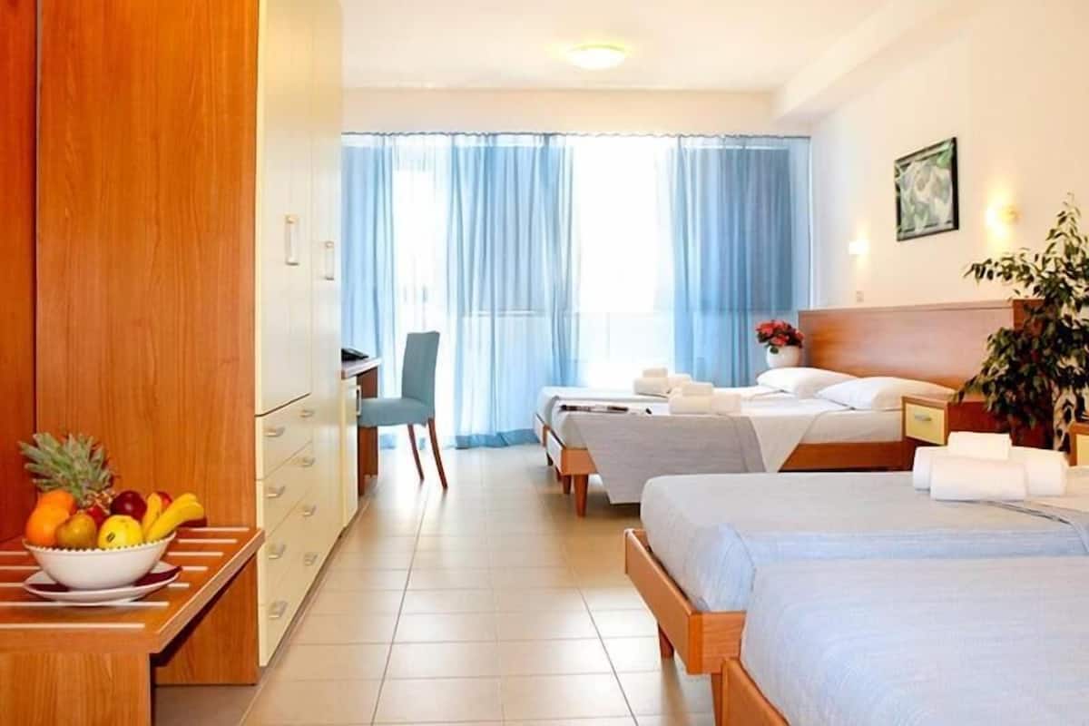 Ein Hotelzimmer mit zwei Betten, einem Schreibtisch und einem Stuhl.