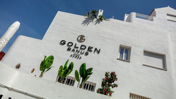 A building with a white facade and the text "GOLDEN BANUS HOMES" on it. - RDR254 - Stunning 1 bedroom Apt. Golden Banús! (Marbella)