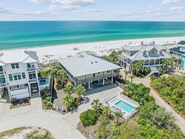 A coastal property with multiple buildings, a swimming pool, and a beach view.