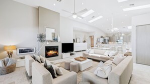 Ein modernes Wohnzimmer mit Kamin, Sofa und Fernseher.