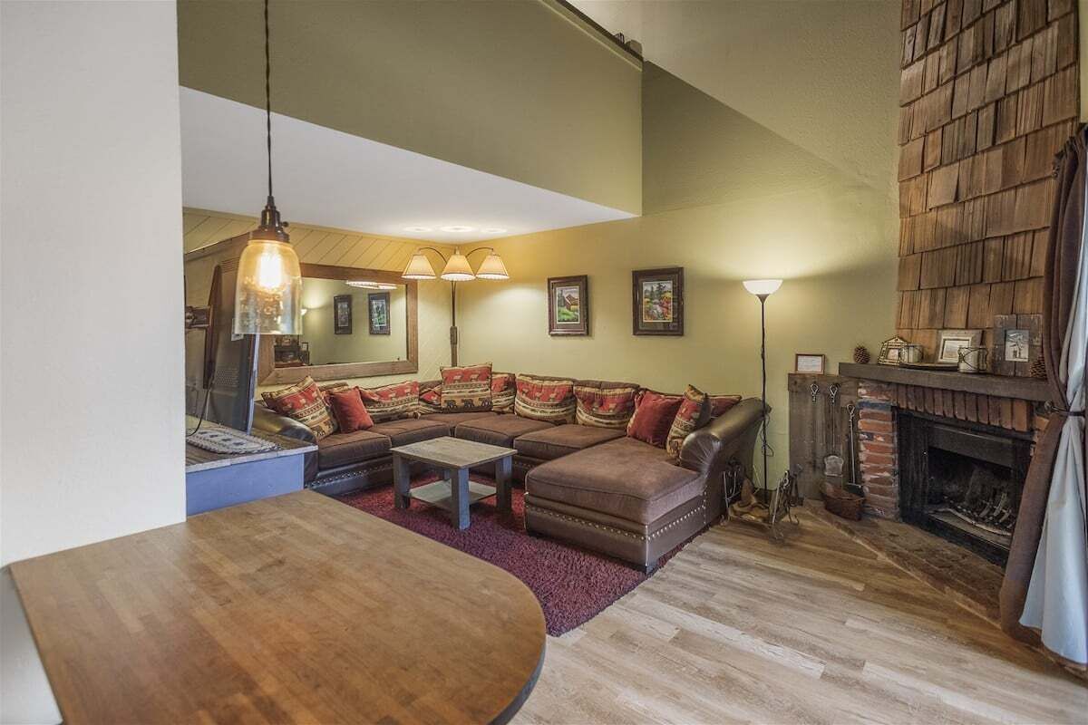 A cozy living room with a sectional sofa, a fireplace, and a dining area.