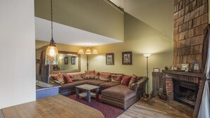 A cozy living room with a sectional sofa, a fireplace, and a dining area.