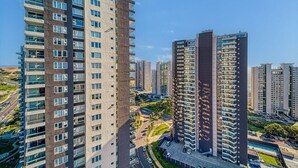 A high-rise residential building with multiple balconies and a clear view of the surrounding urban area. - Galerna Home 2BR W/Balcony, Wifi & Parking. (Concón)