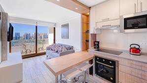 A modern kitchen with a large window, a dining area, and a view of a cityscape. - Wood Summer 2B W/Parking, Wifi & View. (Viña del Mar)