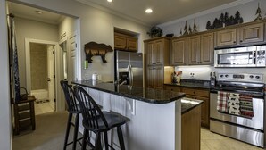 A modern kitchen with a central island, stainless steel appliances, and wooden cabinets. - Unbeatable views at 5,200 ft and walking distance to slopes. (Sugar Mountain)