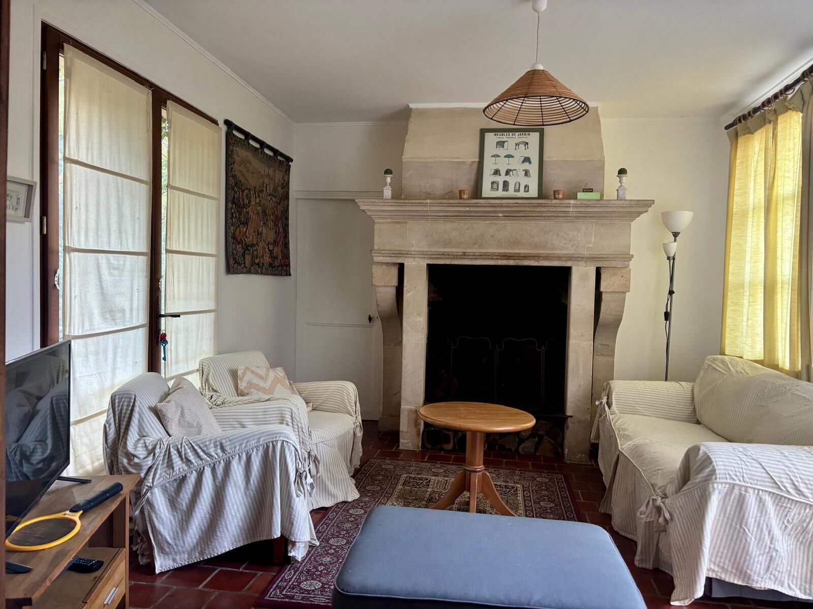 A living room with a fireplace, two sofas, a small table, and a television.