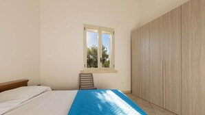 A bedroom with a bed, a window, a chair, and a wardrobe. - 1755 Casina Farnarari - Appartamento 1 by Barbarhouse (Monteroni di Lecce)