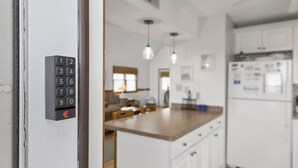 A modern kitchen with white cabinets, a wooden countertop, and a built-in refrigerator.