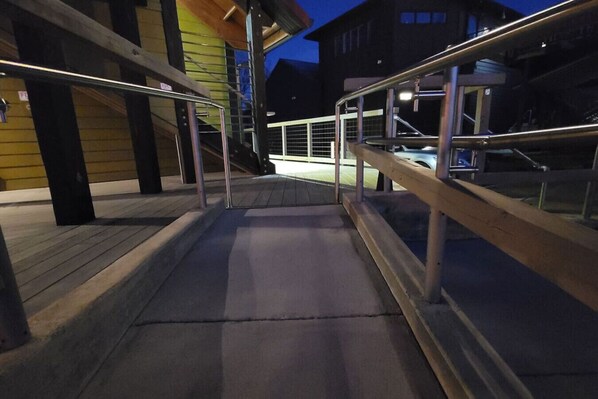 A nighttime outdoor staircase with metal railings leading to a building entrance.