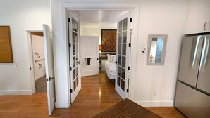Une cuisine moderne avec un réfrigérateur en acier inoxydable, une table à manger en bois et un revêtement mural décoratif.