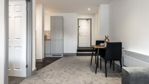 Una cocina moderna con gabinetes blancos, una encimera y un horno empotrado.
