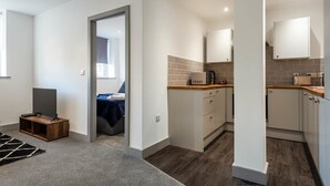 Un apartamento moderno con sala de estar, cocina y dormitorio.