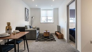 Una sala moderna con un sofá, una mesa de comedor y un televisor.