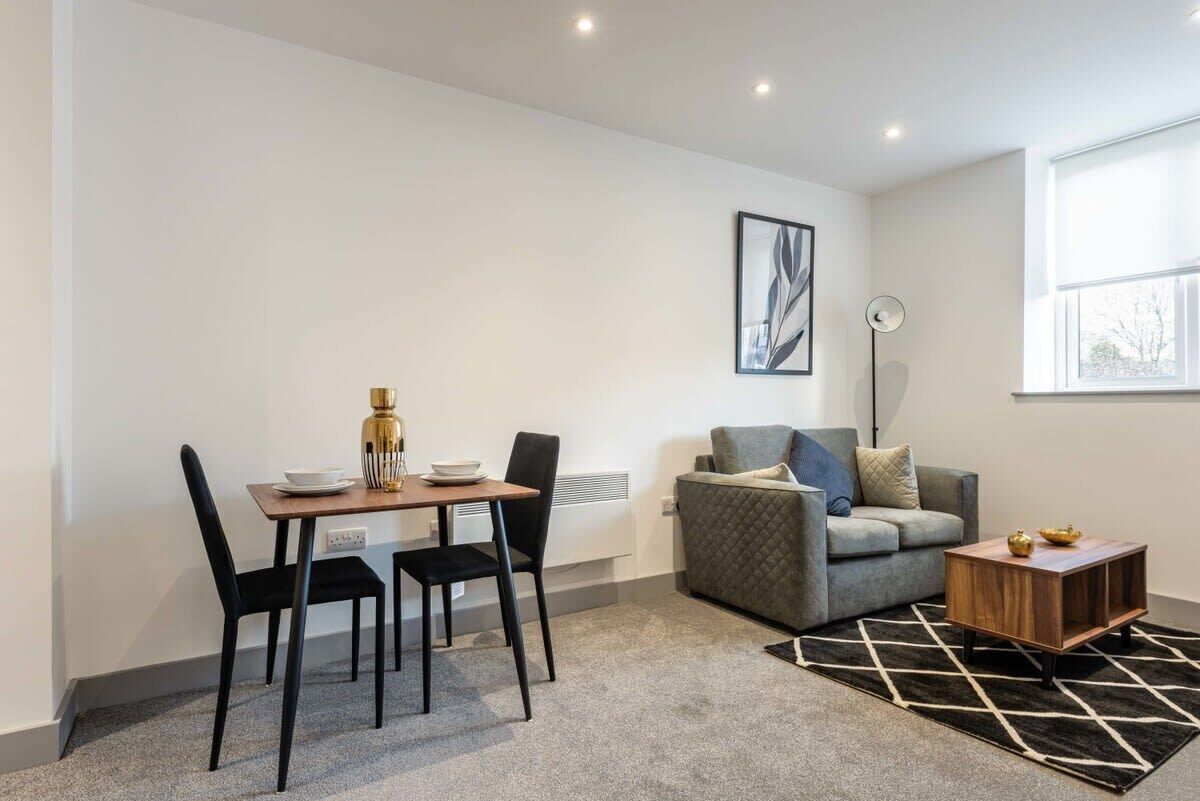 A modern living room with a dining table, chairs, a sofa, and a coffee table.