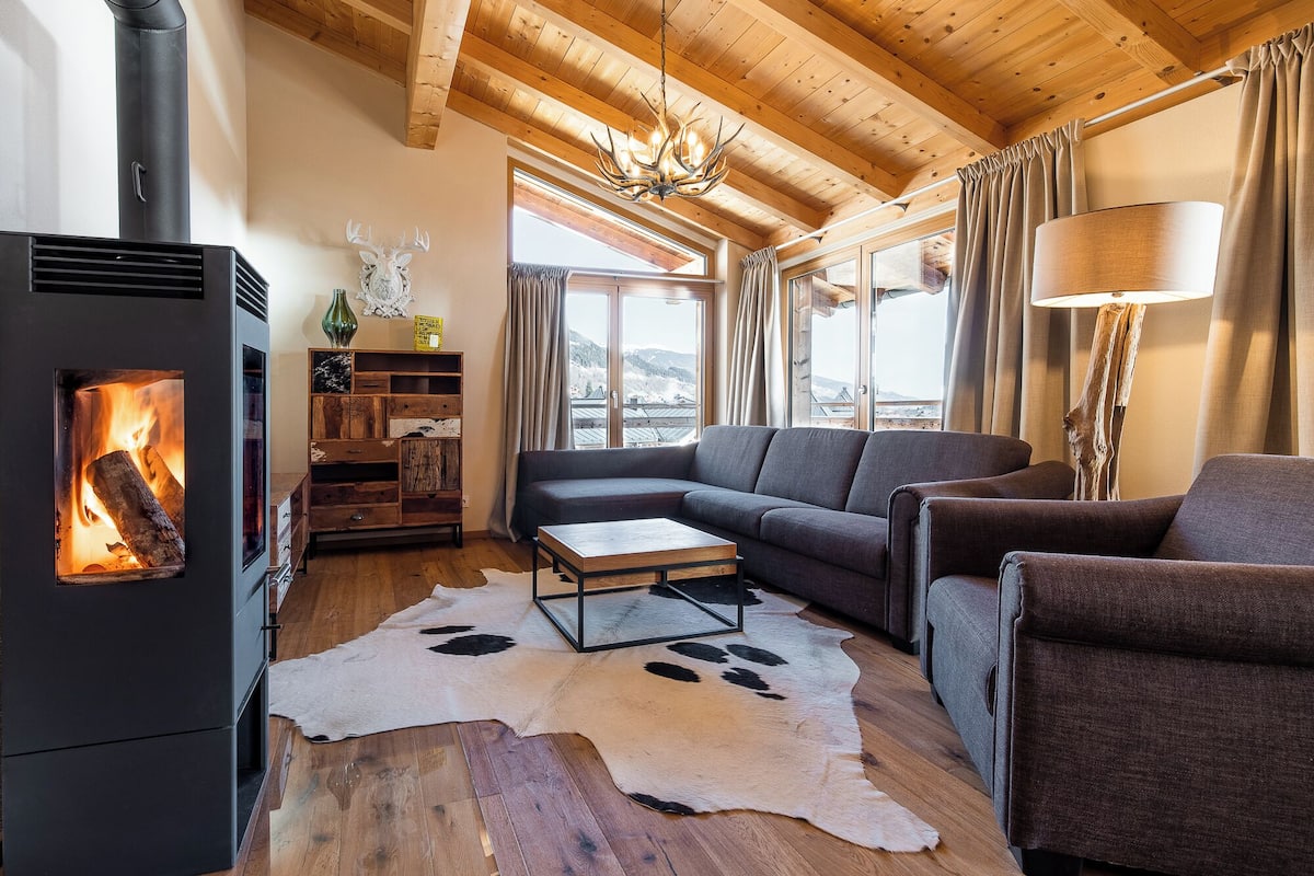 A cozy living room with a fireplace, a sofa, a coffee table, and a rug.