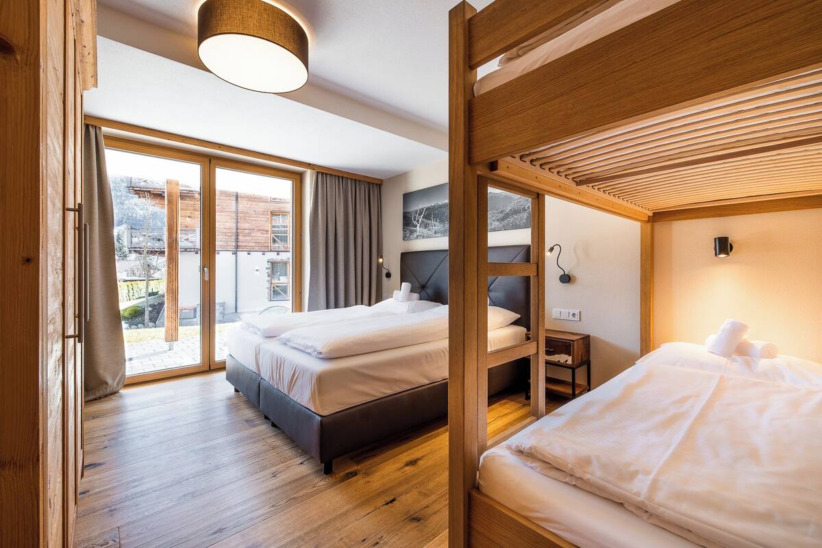Una habitación de hotel moderna con dos camas, un ventanal con vistas al exterior e iluminación en el techo.