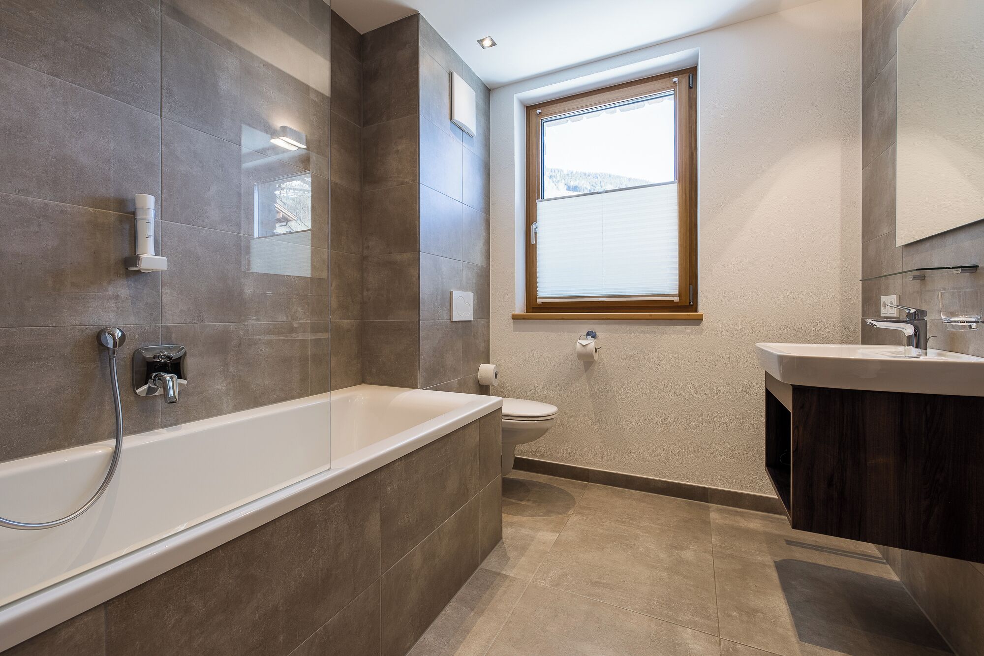 Une salle de bain moderne avec une baignoire, des toilettes et un lavabo.
