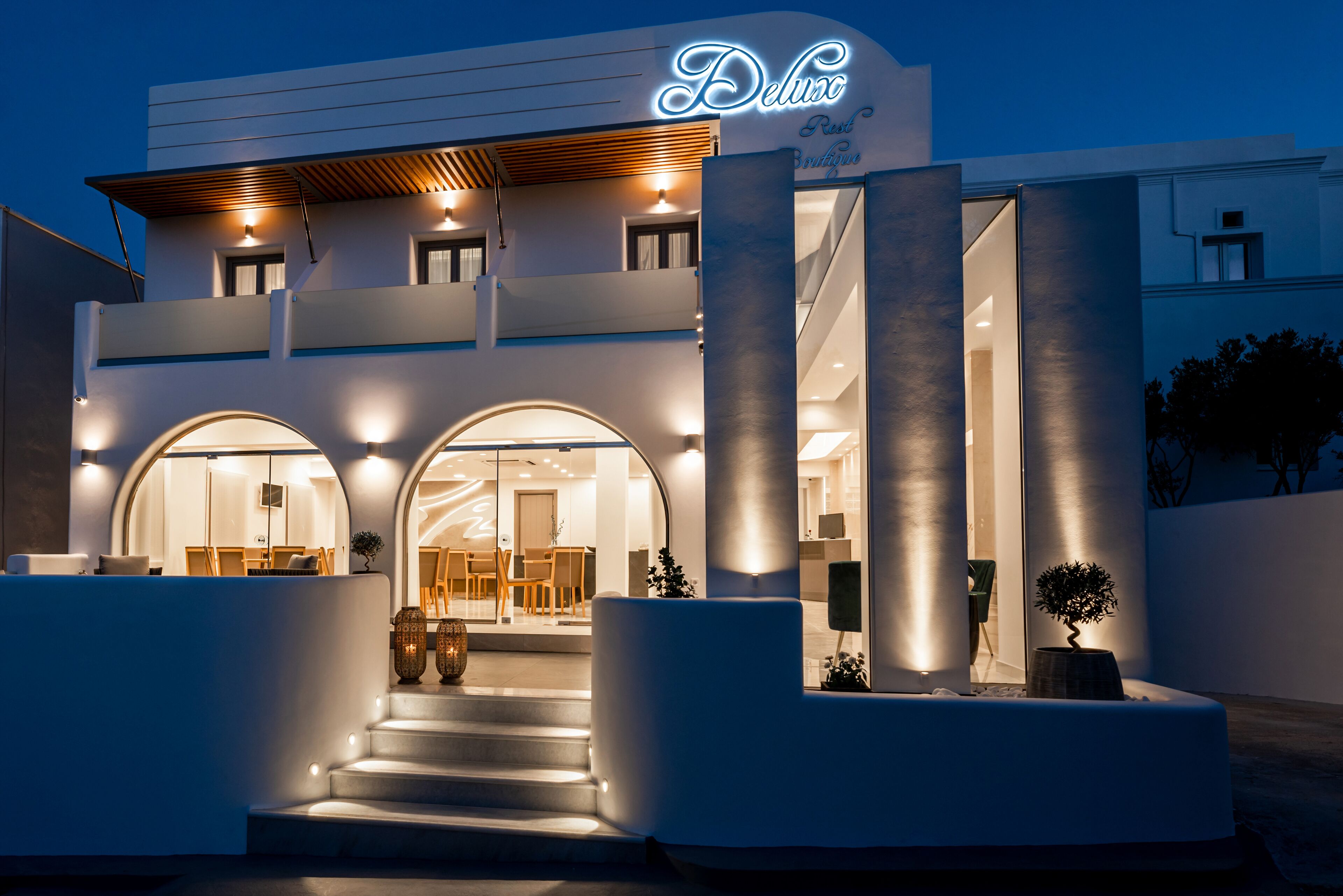 A modern hotel with a prominent entrance, a visible reception area, and a staircase leading to the upper floors.
