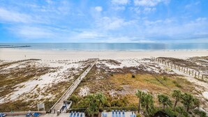 A beach view with a wooden walkway leading to the shore, palm trees, and beach chairs. - Great Rates! Book Now and Save*2BR/2BA On Beach*Sleeps 8*7th floor (Orange Beach)