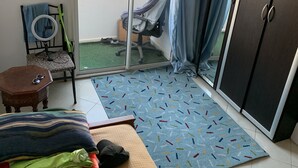 Une chambre avec un lit, un bureau, une chaise, une armoire et une vue sur le balcon extérieur.