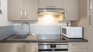 Una cocina moderna con electrodomésticos de acero inoxidable, microondas integrado y horno digital.