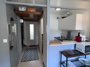 A compact kitchen with a microwave, toaster, and sink.