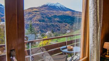 A balcony with a view of a mountain and forest.