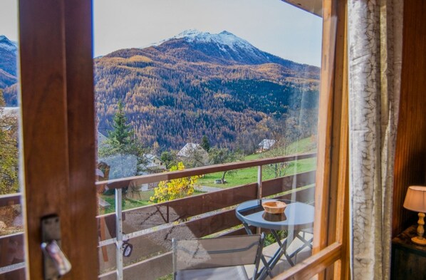 Un balcón con vistas a una montaña y un bosque.