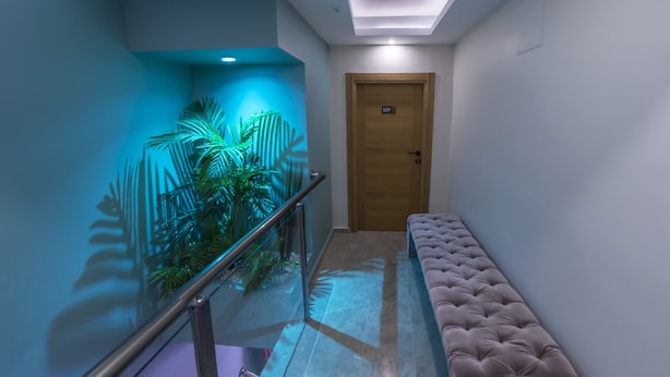 A hallway with a glass railing, a bench, and a door marked with the number 109.
