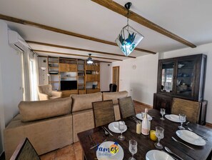 A living room with a sofa, dining table set for six, and a bookshelf. - 3BR Family Apt Near Beach  AC TV17 (Torrevieja)