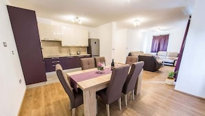 A compact living space with a dining area, kitchenette, and seating area.