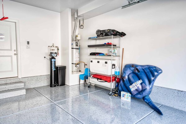 A clean, well-lit room with a metal shelving unit against the wall, a blue chair, and a blue sculpture on the floor.