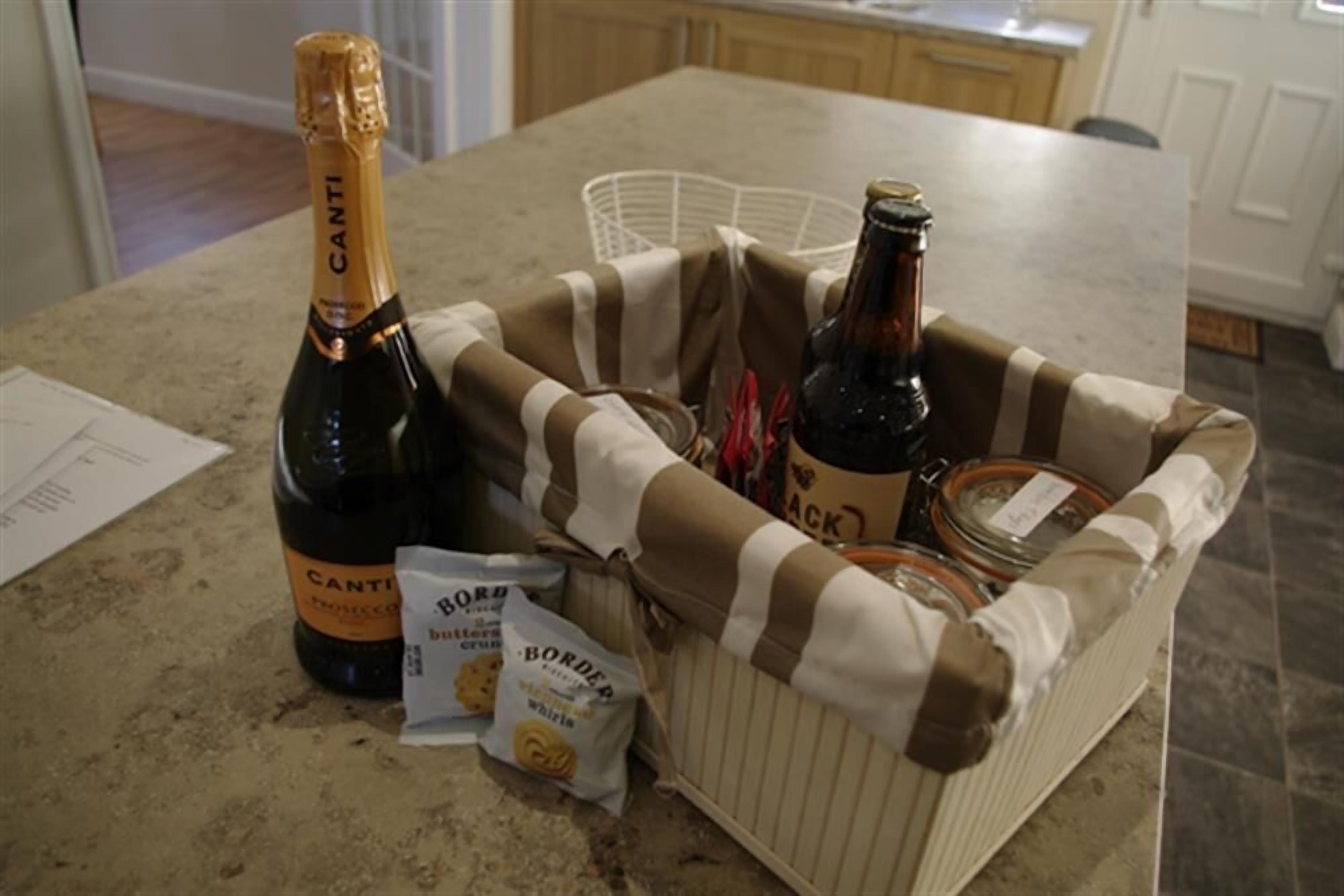 A kitchen counter with a bottle of Canti champagne, a bottle of beer, and two bags of Border biscuits.
