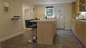 Une cuisine moderne avec un îlot central, des meubles en bois et un tabouret de bar.