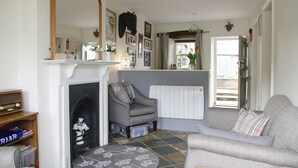 A living room with a fireplace, a sofa, a chair, and a large mirror.