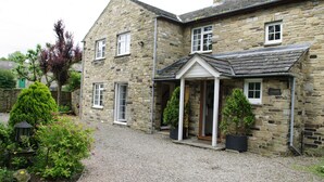 A stone building with a gravel driveway and potted plants.