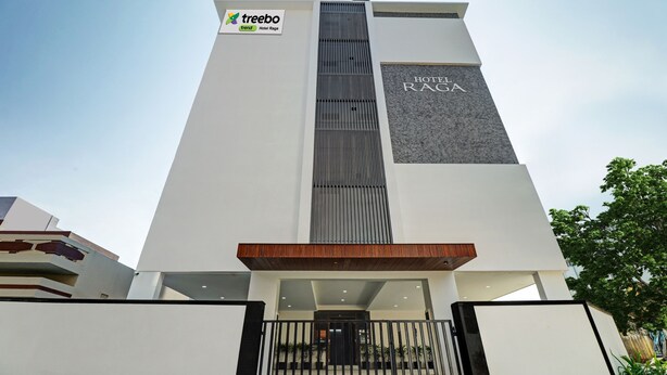 A modern hotel with a prominent vertical design, a sign for 'Hotel Raga', and a 'treeboo trend' logo. - Treebo Raga (Visakhapatnam)