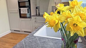 A kitchen with a modern design, featuring a built-in oven and a marble countertop. - 3 bedroom accommodation in Buxton (Buxton)