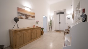 A hallway with a wooden cabinet, a painting, and a door with a sign. - Dimora Fantasia Charme B&B (Bari)