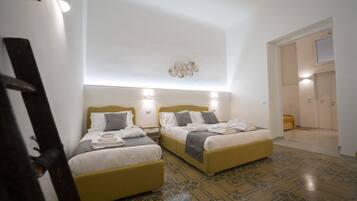 Habitación de hotel con dos camas, piso estampado y lámpara moderna.