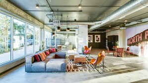A spacious indoor area with a sofa, chairs, a coffee table, and a large window.